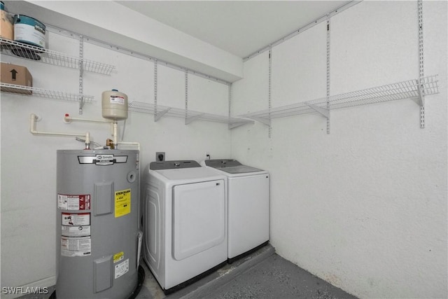 clothes washing area featuring separate washer and dryer and electric water heater