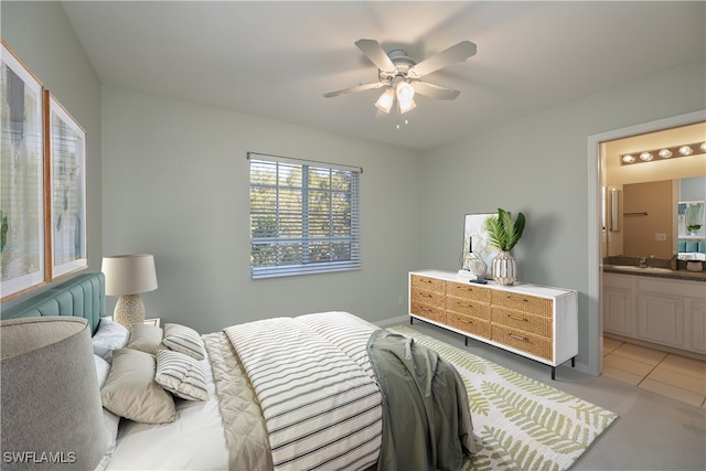 tiled bedroom featuring ensuite bath, ceiling fan, and sink