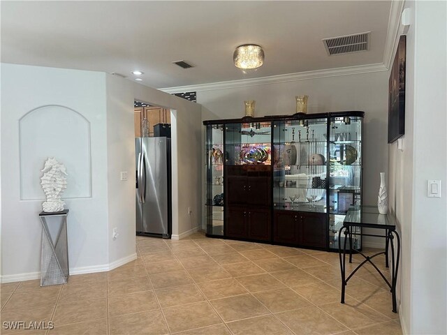 kitchen featuring light tile patterned floors, visible vents, baseboards, and stainless steel refrigerator with ice dispenser