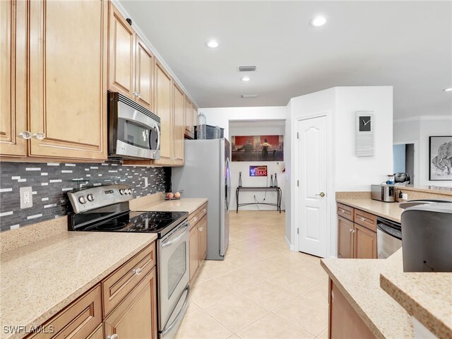 kitchen with light stone counters, visible vents, backsplash, and stainless steel appliances