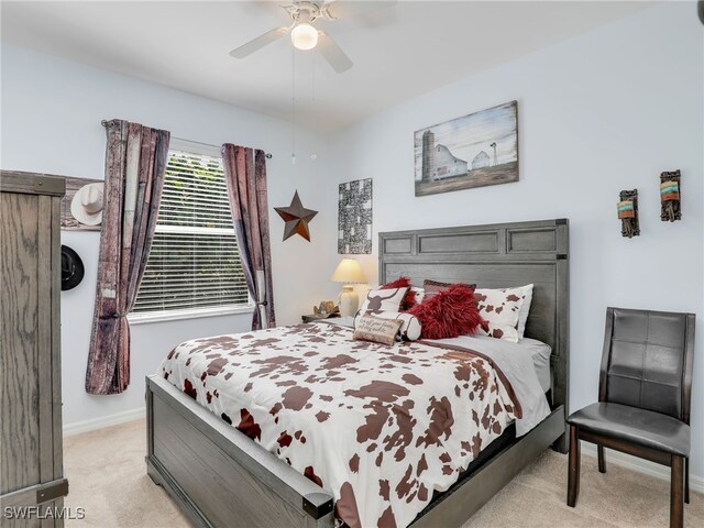 bedroom featuring baseboards, light carpet, and ceiling fan