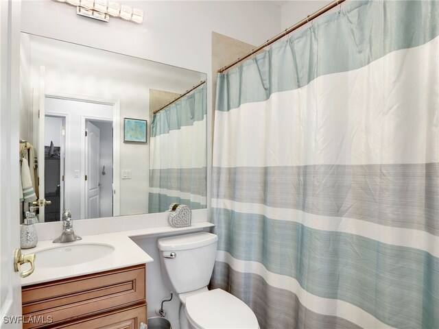 bathroom featuring vanity, a shower with shower curtain, and toilet