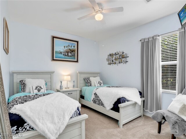 bedroom featuring light carpet and a ceiling fan