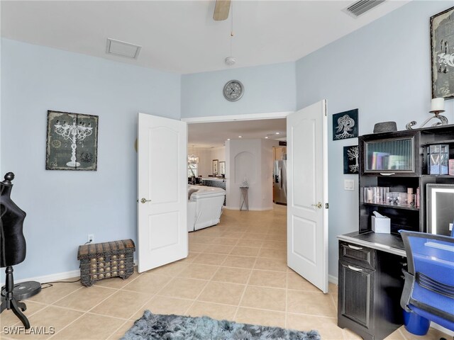 tiled office featuring baseboards, ceiling fan, and an accent wall