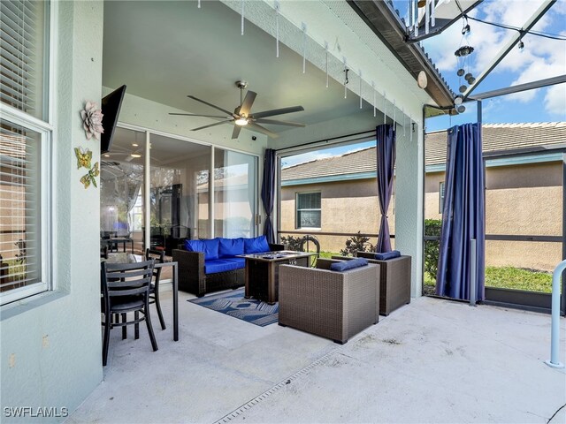 view of patio / terrace featuring glass enclosure, a ceiling fan, and an outdoor hangout area