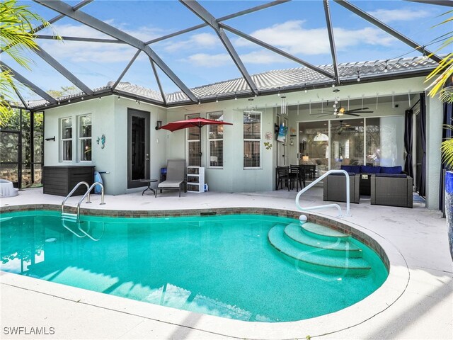 outdoor pool with glass enclosure, a patio, ceiling fan, and outdoor lounge area