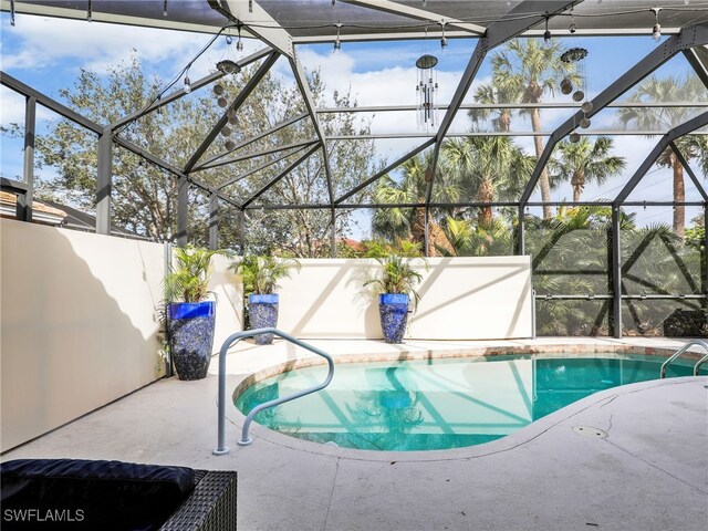 pool with glass enclosure and a patio area