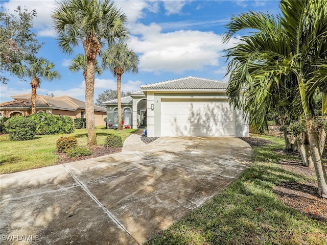 view of front of house with a front yard, stucco siding, concrete driveway, a garage, and a tiled roof