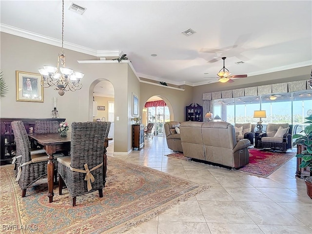 tiled dining room with ceiling fan with notable chandelier and crown molding