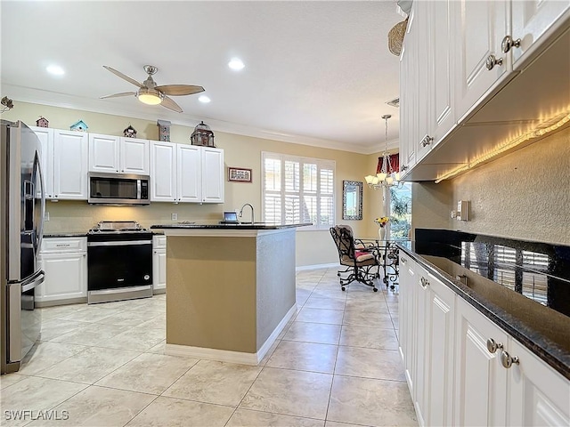 kitchen featuring stainless steel appliances, a center island with sink, white cabinetry, ceiling fan with notable chandelier, and ornamental molding