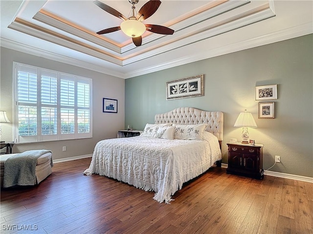 bedroom with wood-type flooring, a raised ceiling, ceiling fan, and crown molding