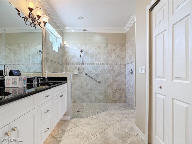 bathroom with tile patterned flooring, a chandelier, vanity, ornamental molding, and a tile shower