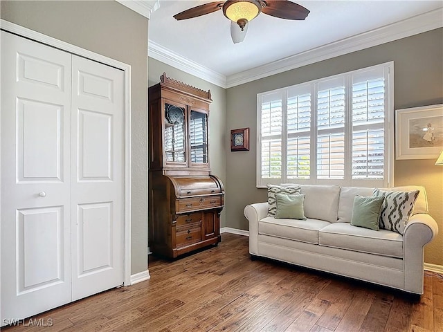 living room featuring dark wood-type flooring, ceiling fan, and ornamental molding