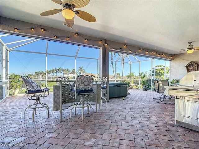 view of patio / terrace with area for grilling, a hot tub, and glass enclosure