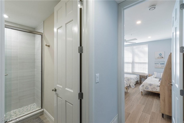 bathroom with an enclosed shower and ceiling fan