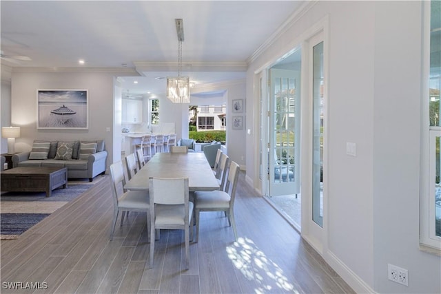 dining room featuring a healthy amount of sunlight, a notable chandelier, and ornamental molding