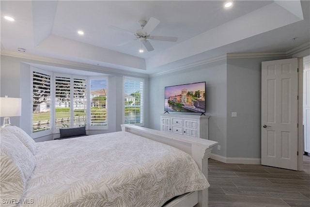 bedroom with a raised ceiling, ceiling fan, and ornamental molding