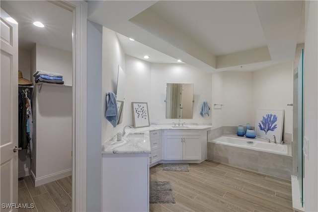 bathroom with tiled bath and vanity