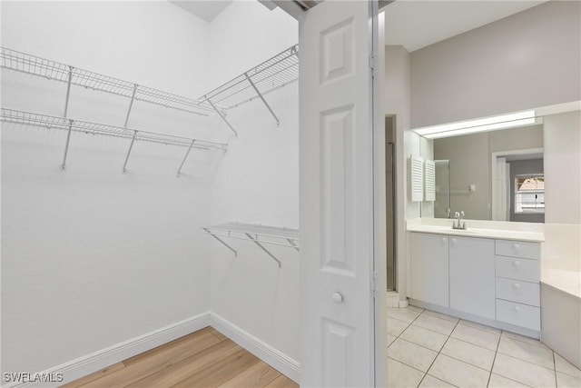 spacious closet with sink and light wood-type flooring