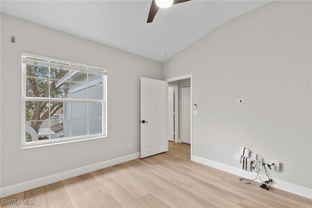 spare room featuring lofted ceiling, ceiling fan, and light wood-type flooring