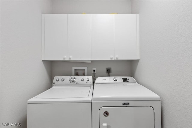 washroom featuring cabinets and washer and dryer