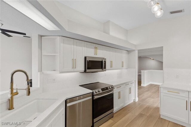 kitchen featuring stainless steel appliances, white cabinetry, ceiling fan, and sink