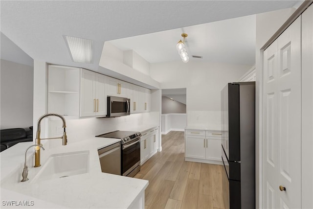 kitchen featuring sink, white cabinets, light hardwood / wood-style floors, kitchen peninsula, and stainless steel appliances