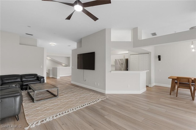 living room with light hardwood / wood-style flooring and ceiling fan