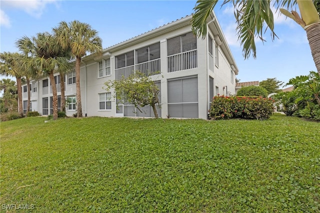 back of property featuring a yard and a sunroom