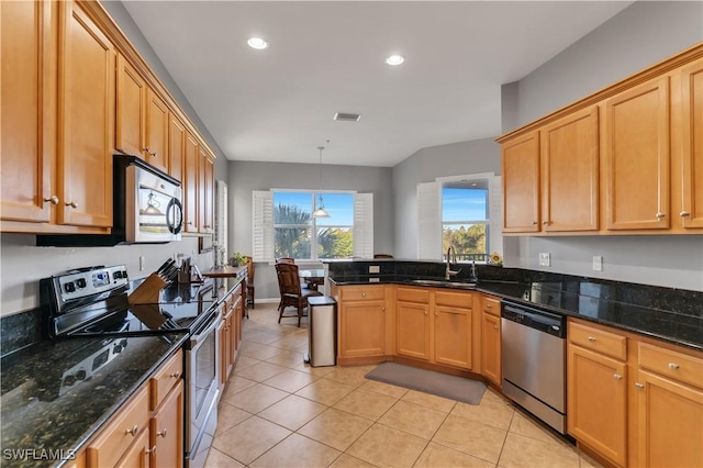 kitchen with pendant lighting, dark stone counters, sink, light tile patterned flooring, and stainless steel appliances