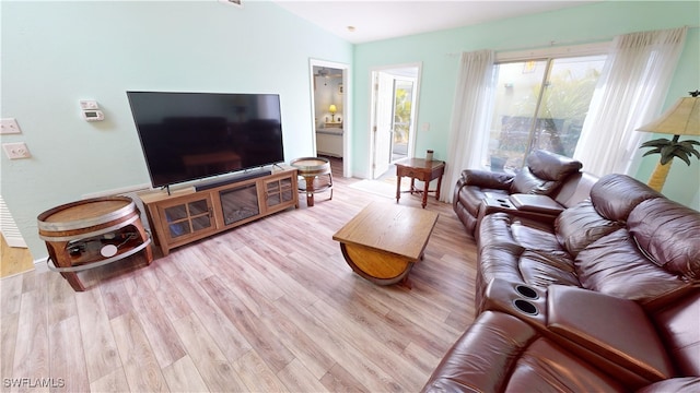 living room featuring light wood-type flooring and vaulted ceiling