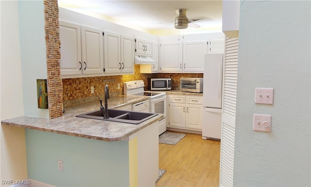 kitchen with white cabinets, white appliances, kitchen peninsula, and tasteful backsplash