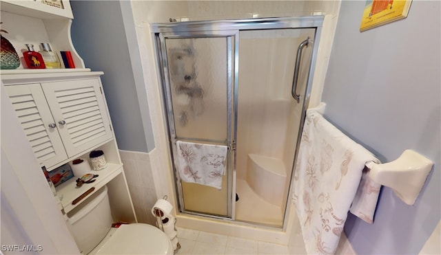 bathroom featuring tile patterned flooring, toilet, walk in shower, and tile walls