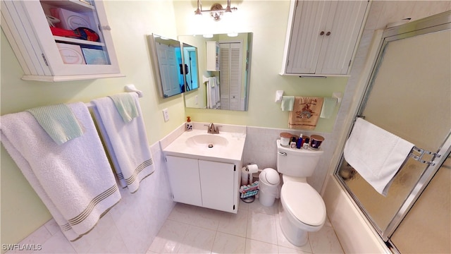 full bathroom featuring vanity, tile patterned floors, toilet, enclosed tub / shower combo, and tile walls