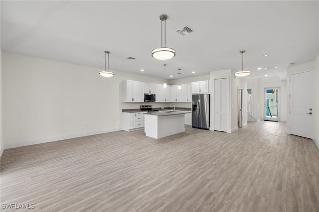 kitchen featuring visible vents, dark countertops, appliances with stainless steel finishes, open floor plan, and light wood-type flooring