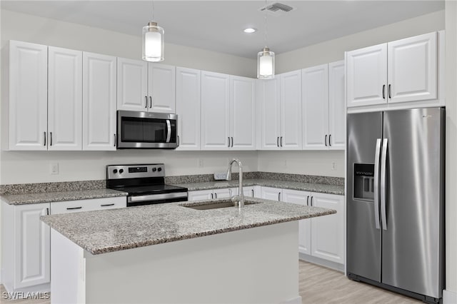 kitchen featuring visible vents, appliances with stainless steel finishes, light stone countertops, white cabinetry, and a sink