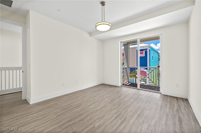 unfurnished room with baseboards, visible vents, and wood finished floors