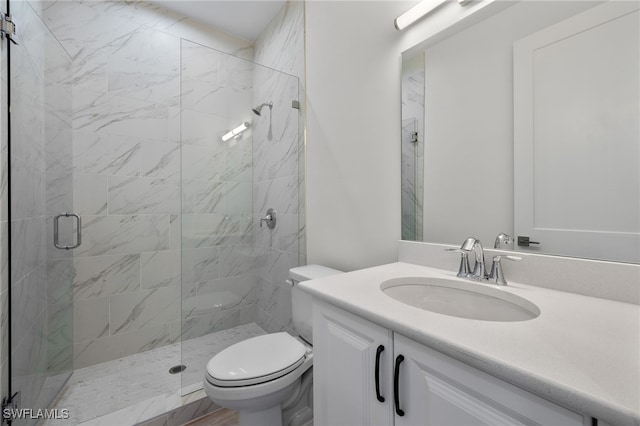 bathroom with a stall shower, vanity, and toilet