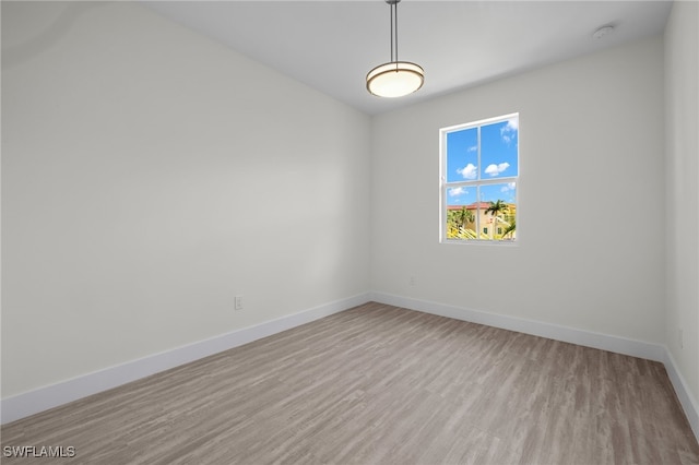 unfurnished room featuring baseboards and wood finished floors