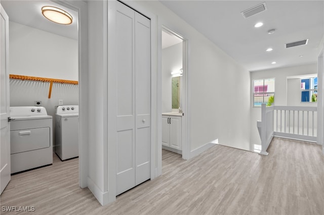 laundry room with laundry area, washing machine and clothes dryer, visible vents, and light wood-style floors