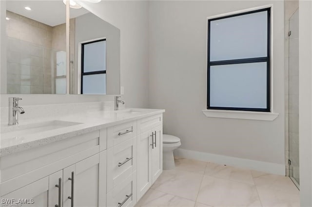 bathroom with vanity, toilet, and a shower with door