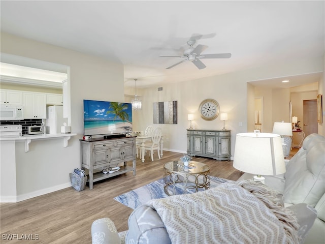 living room featuring ceiling fan and light wood-type flooring