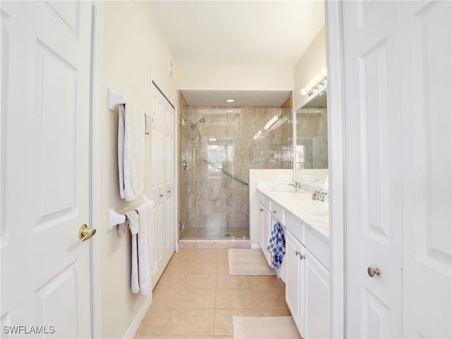 bathroom with a shower with door, tile patterned floors, and vanity