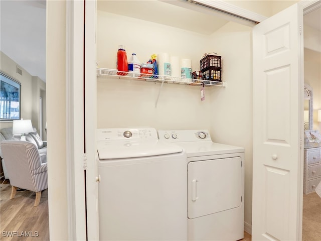 laundry room featuring washer and clothes dryer and light wood-type flooring