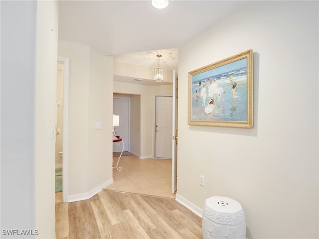 hall featuring a notable chandelier and light hardwood / wood-style flooring