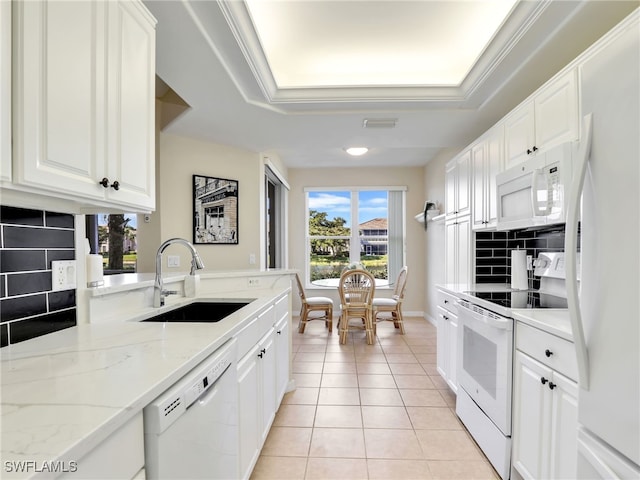 kitchen featuring sink, white cabinets, white appliances, light tile patterned flooring, and a tray ceiling