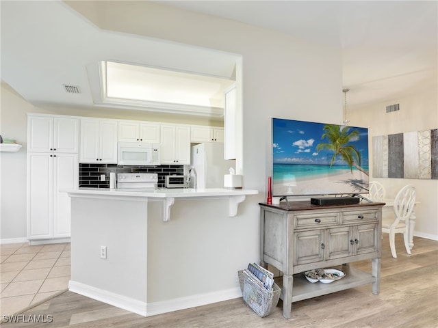 kitchen with white appliances and white cabinetry