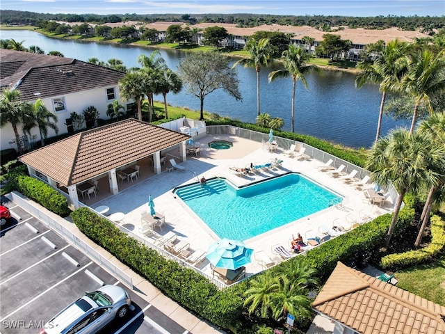 view of swimming pool featuring a patio and a water view