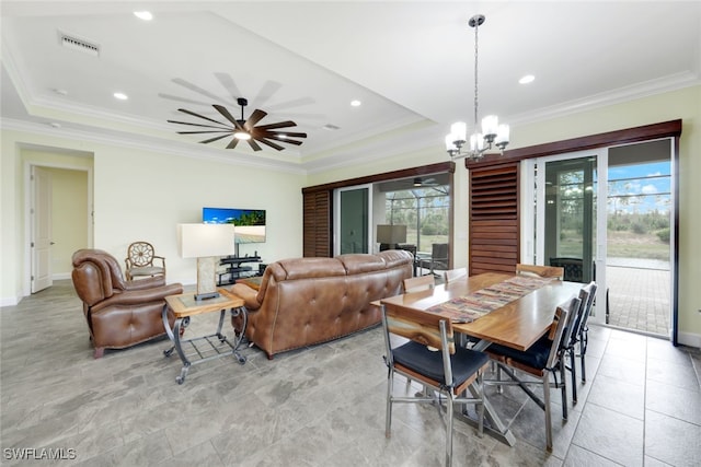 dining space featuring a tray ceiling, ceiling fan with notable chandelier, and crown molding