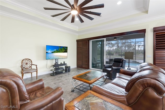 living room with a tray ceiling and ornamental molding